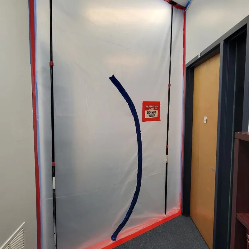 Commercial mold remediation containment chamber with sealed zipper entry, "Do Not Enter" safety signage, and negative air protection installed to prevent cross-contamination in a Monmouth County business property.